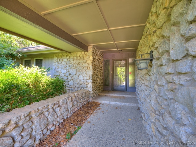 5704 E 65th St, Tulsa, OK 74136 - doorway to property featuring stone siding