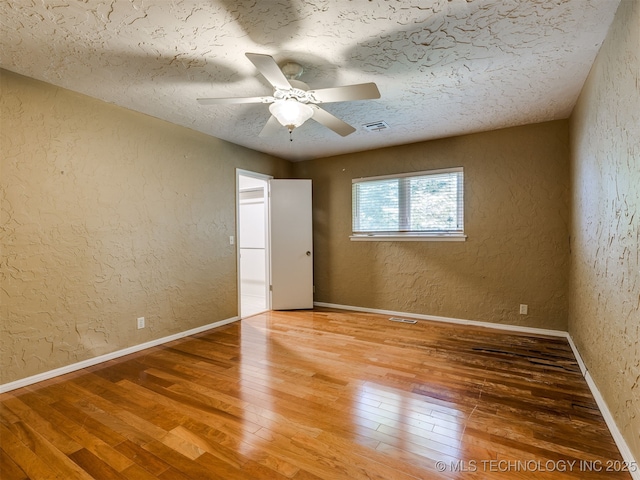 5704 E 65th St, Tulsa, OK 74136 - unfurnished bedroom featuring a textured wall, hardwood / wood-style flooring, a textured ceiling, and a ceiling fan