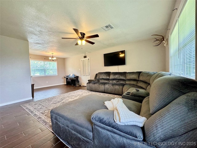 1404 Compelube Rd, Mcalester, OK 74501 - living room featuring a chandelier, a ceiling fan, a textured ceiling, and dark wood-style floors