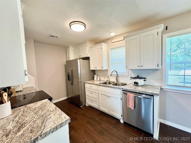 1404 Compelube Rd, Mcalester, OK 74501 - kitchen featuring stainless steel appliances, dark wood-style flooring, decorative backsplash, a textured ceiling, and white cabinetry