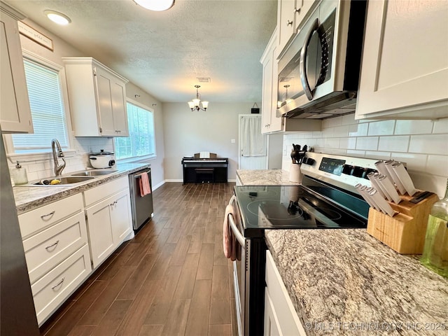 1404 Compelube Rd, Mcalester, OK 74501 - kitchen featuring appliances with stainless steel finishes, a chandelier, a textured ceiling, white cabinets, and dark wood-style flooring