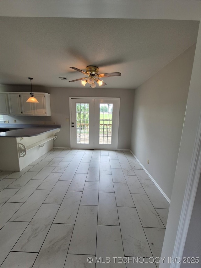 2200 SW Wolf Run Ct, Claremore, OK 74019 - unfurnished living room with baseboards and a ceiling fan