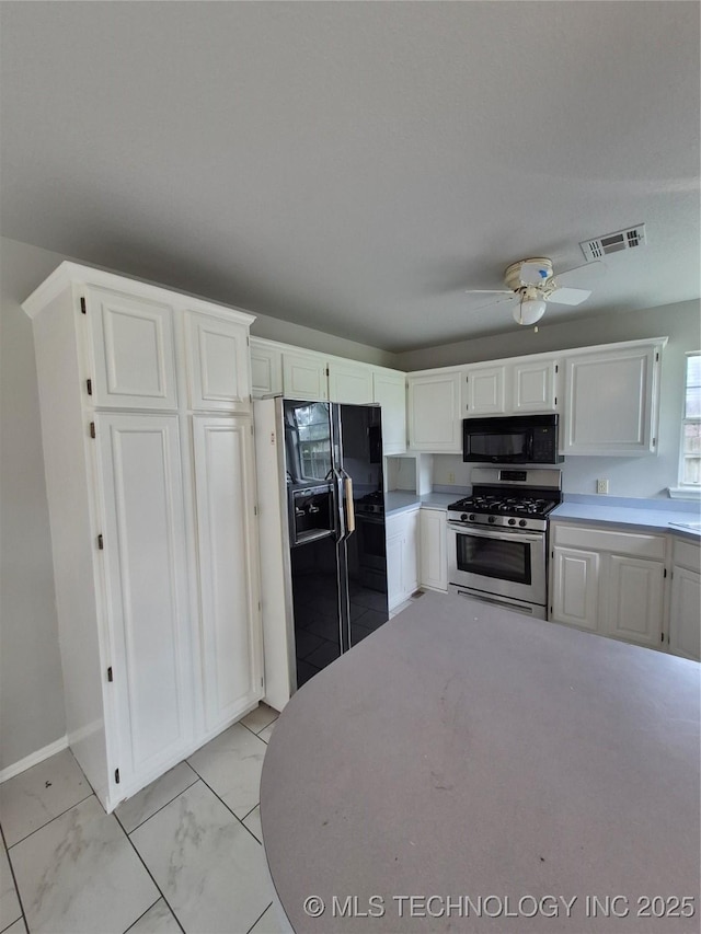 2200 SW Wolf Run Ct, Claremore, OK 74019 - kitchen with black appliances, white cabinetry, light countertops, and a ceiling fan