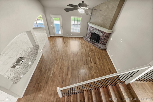 1317 W Dover St, Broken Arrow, OK 74012 - unfurnished living room featuring a fireplace, wood finished floors, plenty of natural light, and a ceiling fan