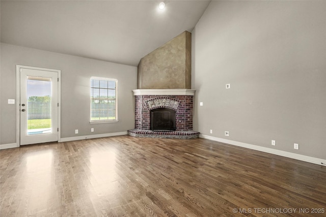 1317 W Dover St, Broken Arrow, OK 74012 - unfurnished living room featuring wood finished floors, vaulted ceiling, and a brick fireplace
