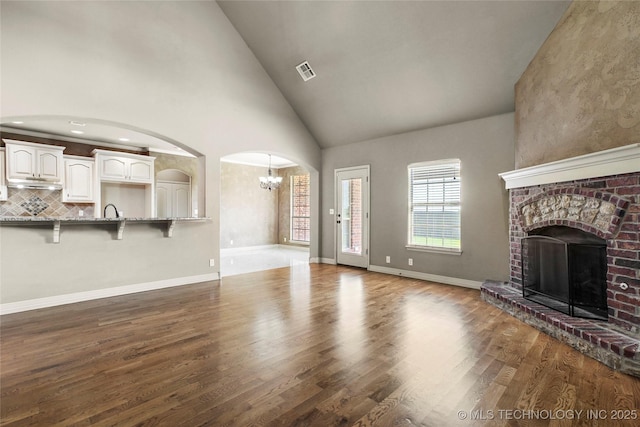 1317 W Dover St, Broken Arrow, OK 74012 - unfurnished living room with a chandelier, a fireplace, wood finished floors, and high vaulted ceiling
