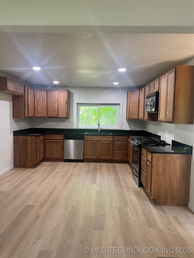 115 S Bryan St, Sperry, OK 74073 - kitchen featuring stainless steel appliances, dark countertops, recessed lighting, brown cabinets, and light wood-style floors