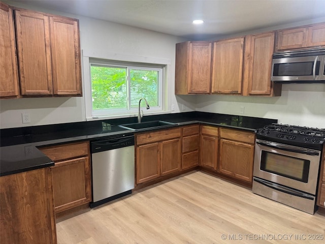 115 S Bryan St, Sperry, OK 74073 - kitchen featuring stainless steel appliances, light wood finished floors, dark countertops, brown cabinets, and recessed lighting