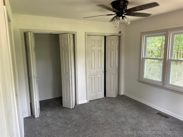 115 S Bryan St, Sperry, OK 74073 - unfurnished bedroom featuring dark carpet, multiple closets, and ceiling fan