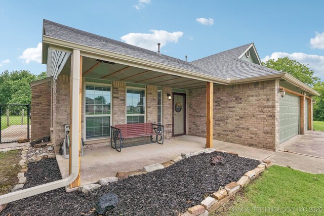 11784 N 154th Ave, Collinsville, OK 74021 - view of front of house featuring brick siding, a shingled roof, a porch, a garage, and driveway