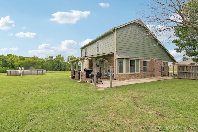 11784 N 154th Ave, Collinsville, OK 74021 - rear view of house with an outdoor pool, a gate, brick siding, and a patio area