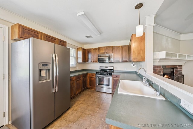 11691 N 193rd E Ave, Collinsville, OK 74021 - kitchen with appliances with stainless steel finishes, a fireplace, decorative light fixtures, brown cabinetry, and light tile patterned floors