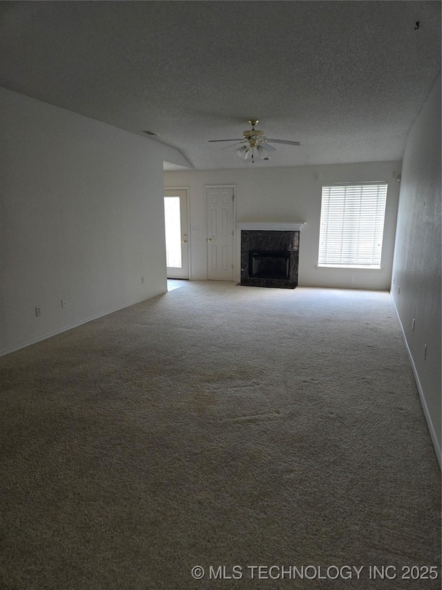 8302 E 84th St, Tulsa, OK 74133 - unfurnished living room with a ceiling fan, plenty of natural light, a high end fireplace, carpet, and a textured ceiling