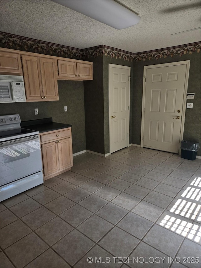 8302 E 84th St, Tulsa, OK 74133 - kitchen with white appliances, a textured ceiling, light tile patterned floors, dark countertops, and light brown cabinetry