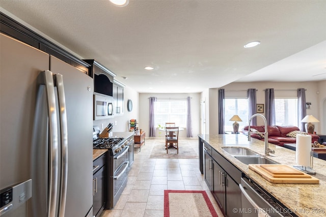 11105 N 145th E Pl, Owasso, OK 74055 - kitchen with stainless steel appliances, healthy amount of natural light, open floor plan, recessed lighting, and light stone counters