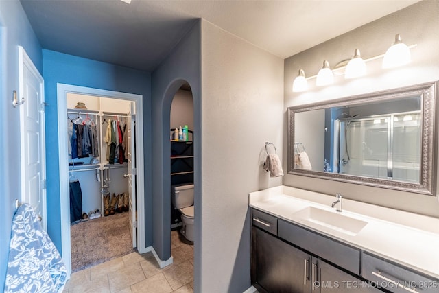 11105 N 145th E Pl, Owasso, OK 74055 - bathroom featuring vanity, a spacious closet, a shower stall, and tile patterned flooring
