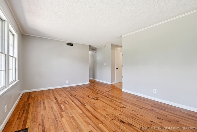 4643 E 59th St, Tulsa, OK 74135 - unfurnished room featuring a textured ceiling, light wood finished floors, and ornamental molding
