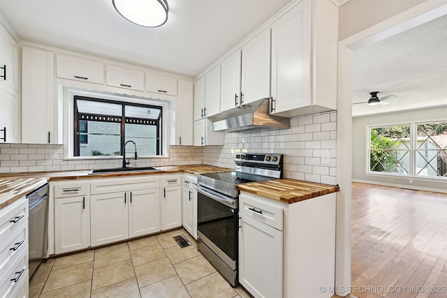 4643 E 59th St, Tulsa, OK 74135 - kitchen with butcher block countertops, appliances with stainless steel finishes, under cabinet range hood, and decorative backsplash