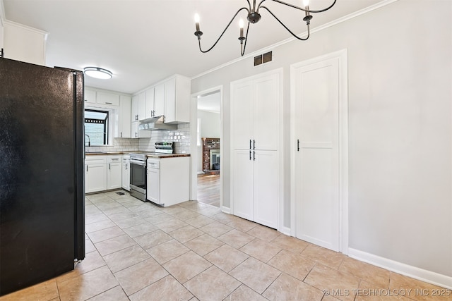 4643 E 59th St, Tulsa, OK 74135 - kitchen featuring freestanding refrigerator, stainless steel electric range oven, under cabinet range hood, crown molding, and light tile patterned floors
