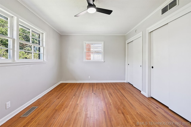 4643 E 59th St, Tulsa, OK 74135 - unfurnished bedroom featuring light wood finished floors, crown molding, two closets, and ceiling fan