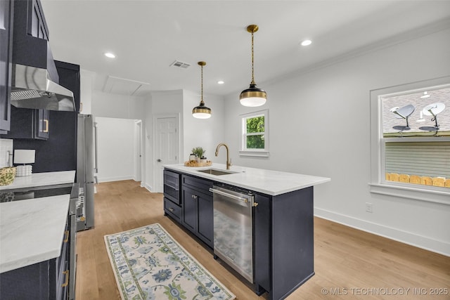 1524 N Main St, Tulsa, OK 74106 - kitchen with stainless steel appliances, dark cabinetry, light wood-style floors, recessed lighting, and ornamental molding