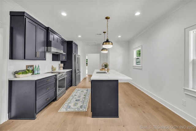 1524 N Main St, Tulsa, OK 74106 - kitchen featuring high end stainless steel range oven, under cabinet range hood, pendant lighting, an island with sink, and recessed lighting