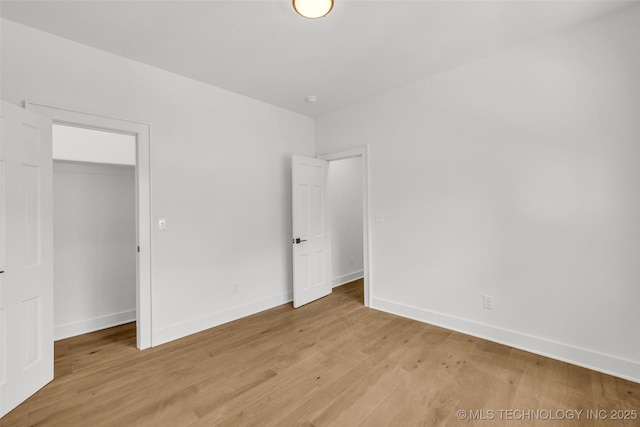 1524 N Main St, Tulsa, OK 74106 - unfurnished bedroom featuring light wood-type flooring and a walk in closet