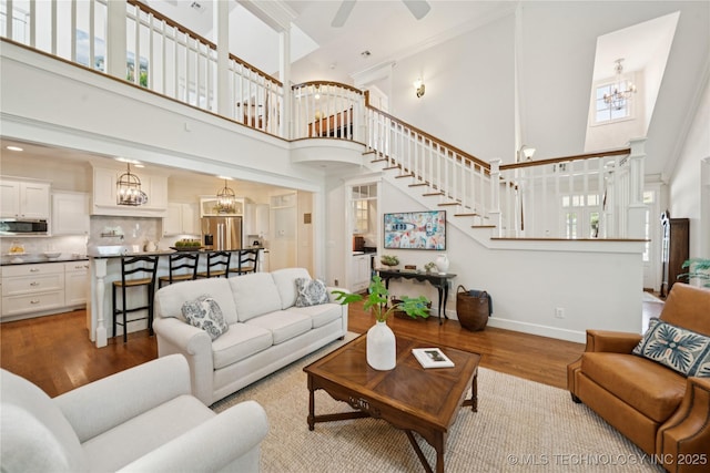 8002 E Galveston Pl, Broken Arrow, OK 74014 - living room with a towering ceiling, wood finished floors, stairway, a chandelier, and ceiling fan