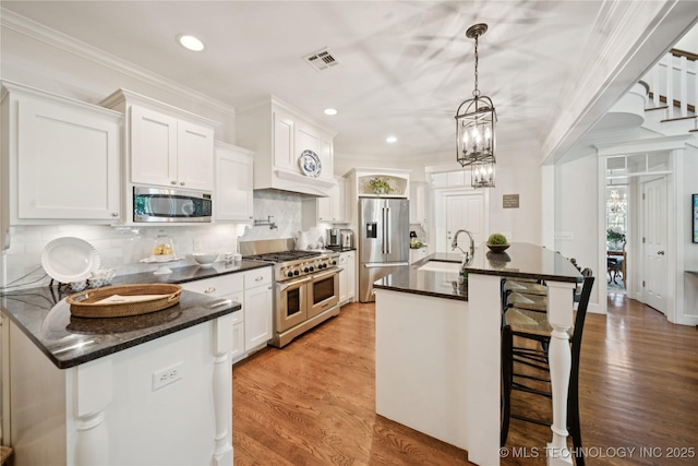 8002 E Galveston Pl, Broken Arrow, OK 74014 - kitchen featuring appliances with stainless steel finishes, white cabinetry, a kitchen bar, light wood-style flooring, and ornamental molding