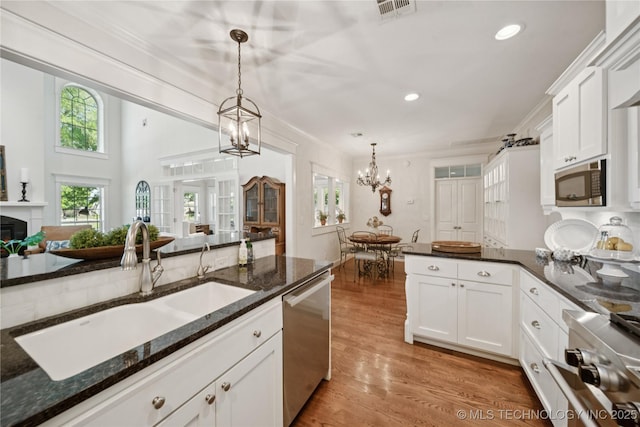 8002 E Galveston Pl, Broken Arrow, OK 74014 - kitchen with stainless steel appliances, white cabinets, plenty of natural light, a chandelier, and ornamental molding