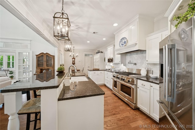 8002 E Galveston Pl, Broken Arrow, OK 74014 - kitchen with high end appliances, a chandelier, light wood-style floors, a kitchen breakfast bar, and ornamental molding