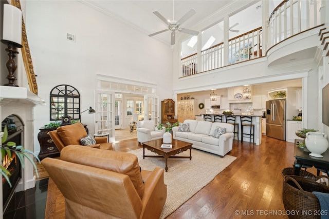 8002 E Galveston Pl, Broken Arrow, OK 74014 - living area with ceiling fan, a high ceiling, wood finished floors, crown molding, and a fireplace