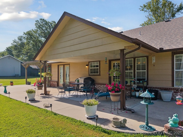 5621 E Hunter Ln, Claremore, OK 74019 - back of property with a yard, a patio, a shingled roof, and brick siding