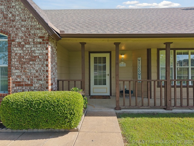 5621 E Hunter Ln, Claremore, OK 74019 - view of exterior entry with roof with shingles, brick siding, and covered porch