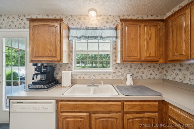 5621 E Hunter Ln, Claremore, OK 74019 - kitchen with dishwasher, wallpapered walls, light countertops, brown cabinets, and a textured ceiling