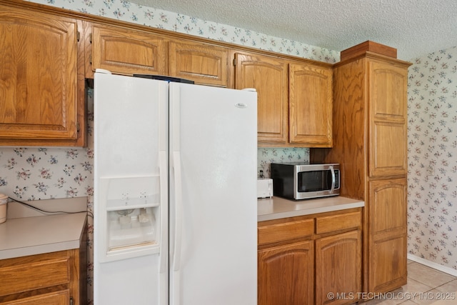 5621 E Hunter Ln, Claremore, OK 74019 - kitchen featuring white refrigerator with ice dispenser, wallpapered walls, stainless steel microwave, light countertops, and a textured ceiling