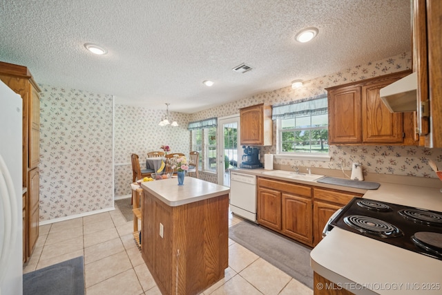 5621 E Hunter Ln, Claremore, OK 74019 - kitchen with white appliances, wallpapered walls, a center island, a textured ceiling, and light countertops
