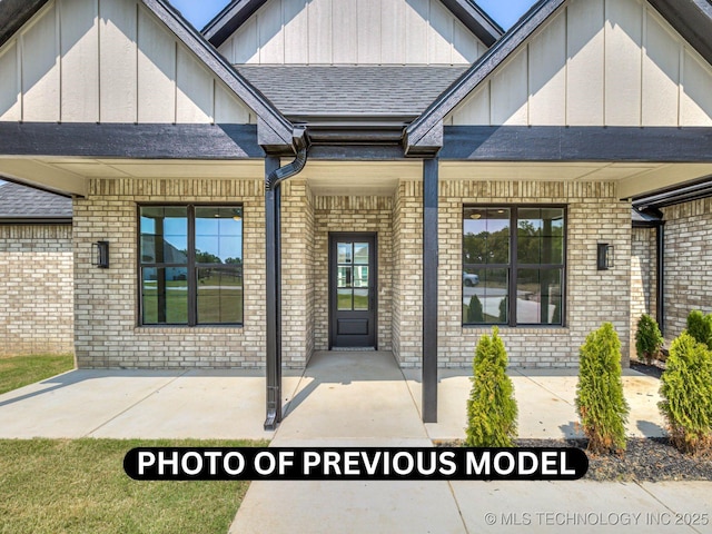 7010 E 137th St, Collinsville, OK 74021 - doorway to property featuring brick siding, board and batten siding, a patio area, and roof with shingles