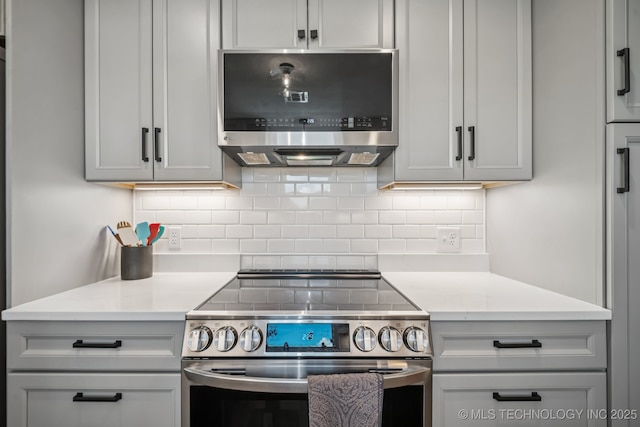 1120 S Sequoyah Dr, Oologah, OK 74053 - kitchen with appliances with stainless steel finishes, light countertops, tasteful backsplash, and gray cabinetry
