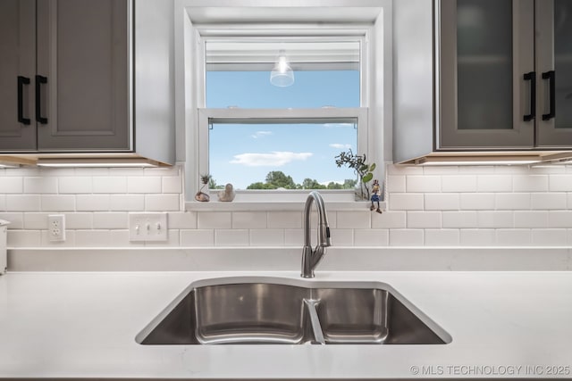 1120 S Sequoyah Dr, Oologah, OK 74053 - kitchen with light countertops, backsplash, and gray cabinetry