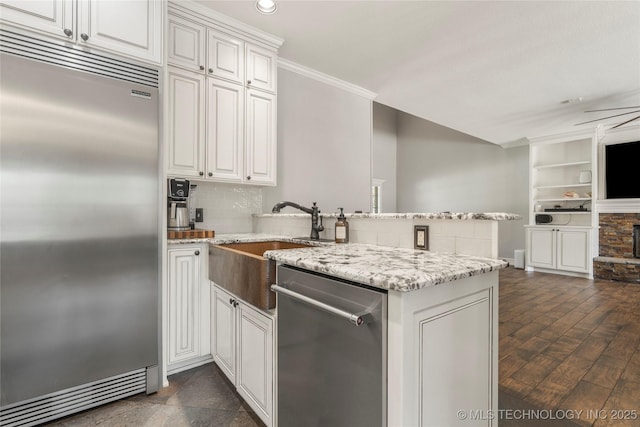 5428 E 88th St, Tulsa, OK 74137 - kitchen featuring stainless steel appliances, a peninsula, crown molding, tasteful backsplash, and light stone counters