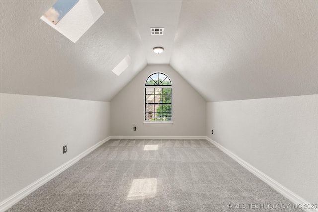 5428 E 88th St, Tulsa, OK 74137 - additional living space featuring a textured ceiling, carpet flooring, vaulted ceiling, and a skylight