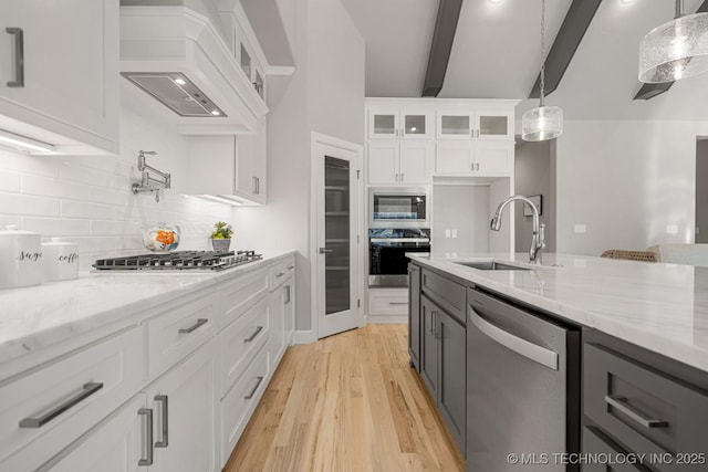3905 S Elder Blvd, Broken Arrow, OK 74012 - kitchen with stainless steel appliances, beam ceiling, glass insert cabinets, light wood-type flooring, and decorative backsplash