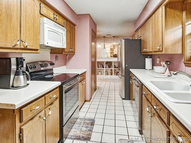 301 S Byrd, Coalgate, OK 74538 - kitchen featuring appliances with stainless steel finishes, light tile patterned floors, light countertops, and brown cabinetry