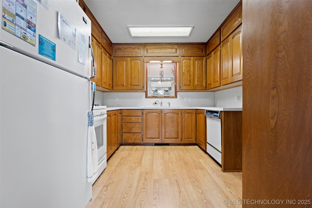 507 S Thompson, Vinita, OK 74301 - kitchen with white appliances, brown cabinetry, and light wood finished floors