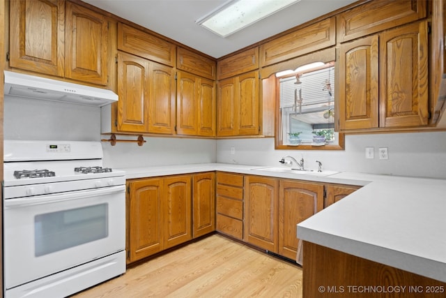507 S Thompson, Vinita, OK 74301 - kitchen featuring white range with gas stovetop, exhaust hood, brown cabinetry, and light countertops