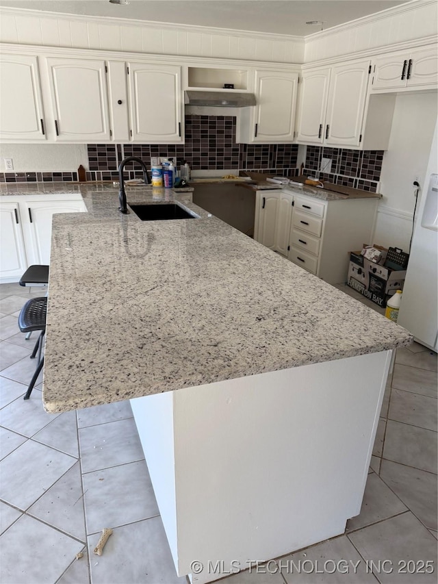 5616 S 91st E Ave, Tulsa, OK 74145 - kitchen featuring light stone counters, backsplash, white cabinetry, and light tile patterned floors