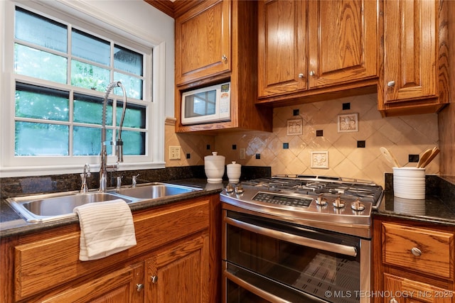 4146 S Birmingham Pl, Tulsa, OK 74105 - kitchen featuring range with two ovens, white microwave, brown cabinets, dark countertops, and backsplash