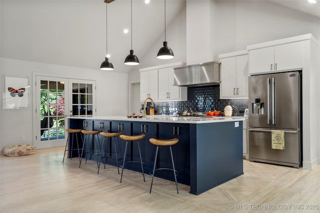 3918 S Evanston Ave, Tulsa, OK 74105 - kitchen featuring stainless steel fridge with ice dispenser, high vaulted ceiling, a kitchen island with sink, light countertops, and white cabinetry