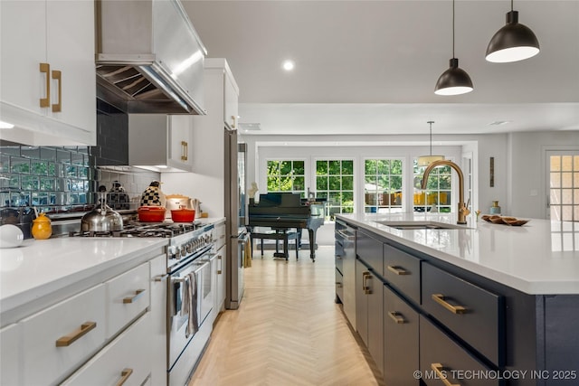 3918 S Evanston Ave, Tulsa, OK 74105 - kitchen featuring appliances with stainless steel finishes, range hood, white cabinets, a kitchen island with sink, and light countertops
